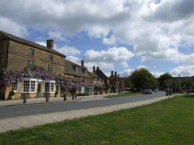 A street view with buildings and trees at Glencoe Cottage in Broadway