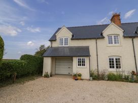 A house with a garage and garden at Glencoe Cottage in Broadway