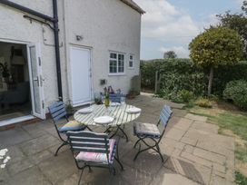 A garden with a table and chairs at Glencoe Cottage in Broadway