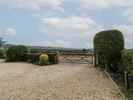 A gravel area with a wooden gate and hedges at Glencoe Cottage Broadway