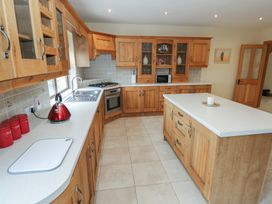 A kitchen with cabinets, sink, stove, and island at Tigh Marie