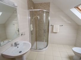 A bathroom with a shower, sink, and toilet at Tigh Marie 