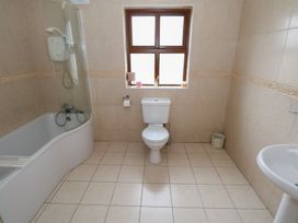 A bathroom with a bathtub, toilet, and sink at Tigh Marie