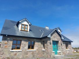 A house with a stone facade and teal door at Tigh Marie 