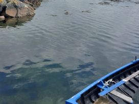 A view of water with a blue boat and rocks at Tigh Marie in 