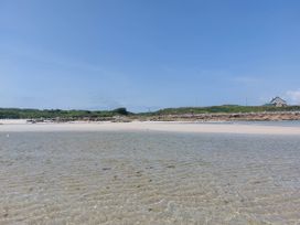 A beach scene with water and a house at Tigh Marie