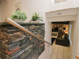 A stairwell with a stone wall and plants leading to a living area at Newlands Fell House, Newlands near Keswick