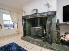 A living room with a fireplace and television at Newlands Fell House in Newlands near Keswick