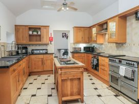 A kitchen with wood cabinets and appliances at Newlands Fell House in Newlands near Keswick