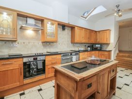 A kitchen with wooden cabinets and appliances at Newlands Fell House in Newlands near Keswick