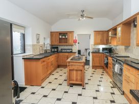 A kitchen with wooden cabinets and appliances at Newlands Fell House Newlands near Keswick