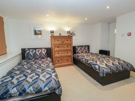 A bedroom with two beds and a wardrobe at Newlands Fell House in Newlands near Keswick
