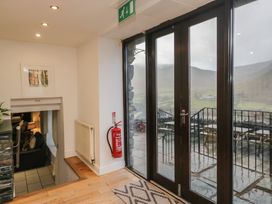 A hallway with sliding doors and wooden stairs at Newlands Fell House in Newlands near Keswick