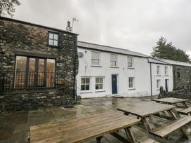 An exterior view of a stone building with patio seating at Newlands Fell House near Keswick