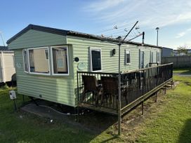 A mobile home with a deck and furniture at Gannet 16 (G16) Bridge Of Allan