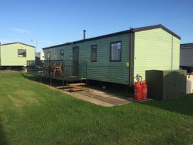 A static caravan with decking and gas cylinders at Gannet 16 (G16) in Bridge Of Allan
