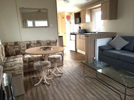 A living room with a sofa and dining table at Gannet 16 (G16) Bridge Of Allan