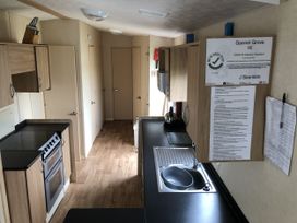 A kitchen with a stove and sink at Gannet Grove 16 in Bridge Of Allan