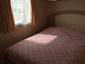 A bedroom with a bed and curtains at Gannet 16 (G16) Bridge Of Allan