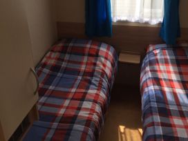 A bedroom with two beds and a side table at Gannet 16 (G16) Bridge Of Allan