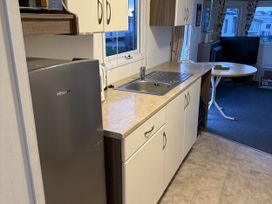 A kitchen with a sink and refrigerator at Jay valley 35 (J35) in Lichfield