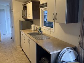 A kitchen with a sink, refrigerator, and kettle at Jay valley 35 (J35) in Lichfield