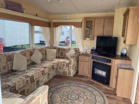 A living room with a sofa and television at Gannet 18 (G18) in Bridlington