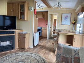 A living room with a television and dining table at Gannet 18 (G18) Bridlington