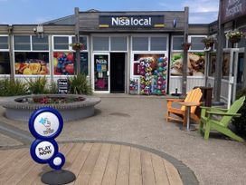 An outdoor shop entrance with seating and signage at Gannet 18 (G18) Bridlington
