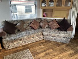 A sofa with cushions and shelves in a living room at Gannet 19 (G19) in Bridlington