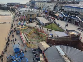 A busy beach area with an amusement park and people at Gannet 19 (G19) in Bridlington