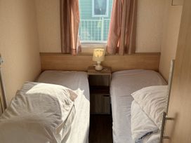 A bedroom with two beds and a lamp on a bedside table at Dunlin dell 45 (D45) Bridlington