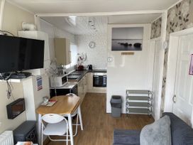 A kitchen with appliances and a dining area at Chalet in Bridlington