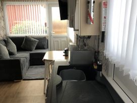 A kitchen with a sofa and table at Chalet in Bridlington