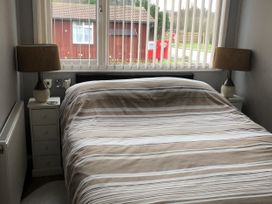 A bedroom with a bed and bedside tables at Chalet in Bridlington