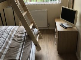 A bedroom with a bed, desk and computer monitor at Chalet in Bridlington