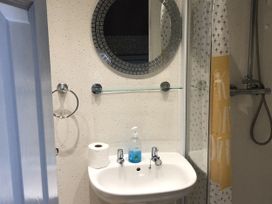A bathroom with a sink, mirror, and shower at Chalet in Bridlington