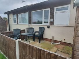 A patio area with chairs and a table at Chalet in Bridlington