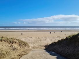 A beach with people walking along the shore at Chalet in Bridlington
