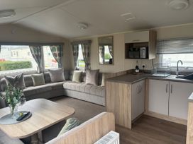 A living room with a sofa and kitchen area at Skegness Holiday Park, Skegness
