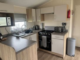 A kitchen featuring a sink, oven, and microwave at Skegness Holiday Park in Skegness
