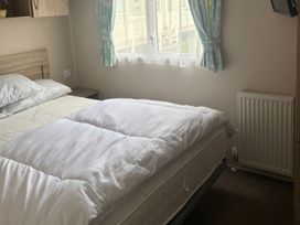 A bedroom with a bed and window at Skegness Holiday Park in Skegness