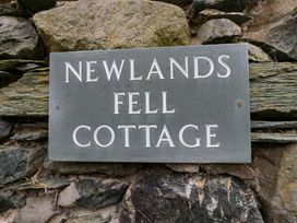 A sign for Newlands Fell Cottage on a stone wall