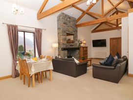 A living room with a dining area and fireplace at Newlands Fell Cottage in Newlands near Keswick