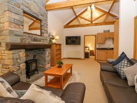 A living room with a sofa, coffee table, and fireplace at Newlands Fell Cottage in Newlands near Keswick