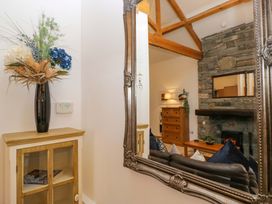 A living room with a mirror and a flower arrangement at Newlands Fell Cottage in Newlands near Keswick