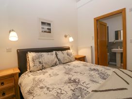 A bedroom with a bed and a door leading to a bathroom at Newlands Fell Cottage in Newlands near Keswick