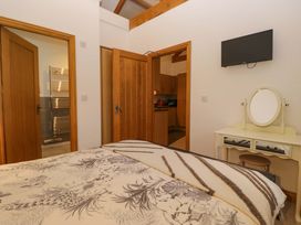 A bedroom with a bed, mirror, and television at Newlands Fell Cottage near Keswick