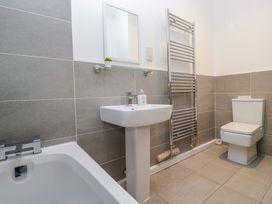 A bathroom with sink, toilet, tub, and towel radiator at Newlands Fell Cottage near Keswick