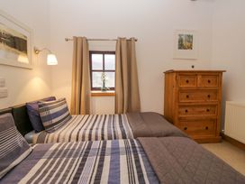 A bedroom with two beds and a chest of drawers at Newlands Fell Cottage in Newlands near Keswick